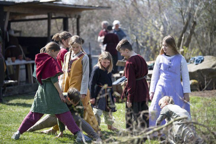 Gøglerbørn i middelaldertøj leger på gøglerpladsen